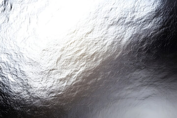 Silver metallic grainy texture background is reflecting light