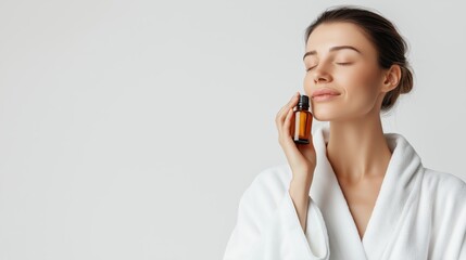 A Woman Relaxing with Essential Oil Bottle in Bathrobe 