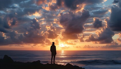 Contemplative silhouette observing a vibrant cloud-strewn sunset above the ocean waves