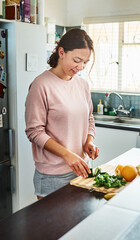 Poster - Cooking, happy and woman with vegetables in kitchen for meal prep for dinner, supper and lunch in home. Recipe, diet and person with cucumber on counter for wellness, nutrition and healthy eating