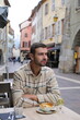 © ajr_images - Cheerful man eating in outdoors table during euro holiday