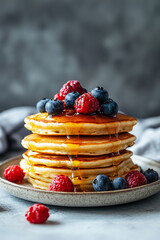 Stack of pancakes with syrup and berries, copy space for breakfast menu on the side 