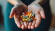 © Suphawan - A person holding a handful of colorful vitamins and supplements, representing health maintenance and wellness