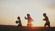 © maxximmm - crowd of kids run. people in the park. happy family kid dream concept. brother sister little children holding a ball silhouette run across the field at sunset. fun happy family kids