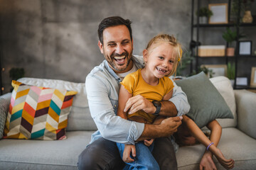 adult single father hold and tickle daughter at home