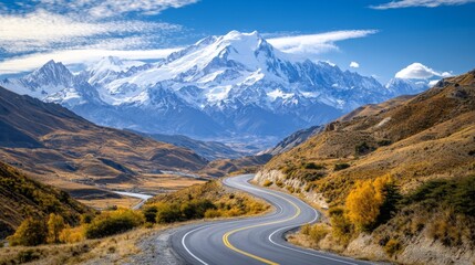 A scenic mountain road with dramatic switchbacks and breathtaking views of snow-capped peaks and valleys, capturing the grandeur of the landscape.