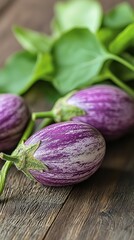 Wall Mural -  A collection of eggplants atop a weathered wooden table, accompanied by a lush, green plant with leaves