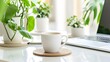 © wanchai - Modern home office setup featuring a slim laptop, coffee in a stylish cup, and a small green plant, with natural light streaming in