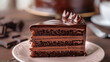 © Preeyada - Decadent Slice of Rich Chocolate Layer Cake with Ganache Frosting on White Plate