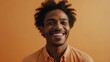 © KLSHKA - portrait of a an extremely happy black man with a light orange background