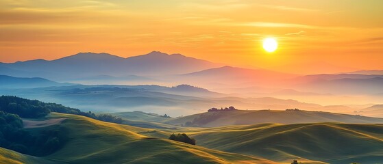 Poster - A beautiful sunrise illuminates rolling hills and distant mountains, casting soft light over a peaceful and misty landscape.