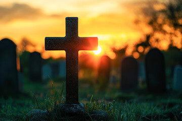 A cross is standing in a cemetery at sunset