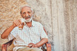 © SensSai/peopleimages.com - Portrait, senior man and drinking beer in home, front porch or ancient architecture on wall. Pensioner, male person and comfort in retirement for beverage, alcohol and relax for elderly care in Italy