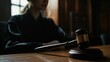 © SKIMP Art - A person sitting at the table, with their hand on top of a gavel in front of them, background blurred, focus on the judge's face and the wooden context of the blurred wooden desk Generative AI