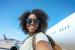 © Nadia Do - Young african american woman taking a selfie photo near the airplane outside, vacation mood scene