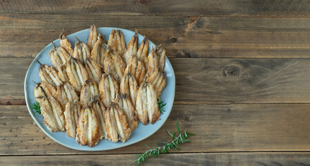 A plate of fried anchovies with herbs on top