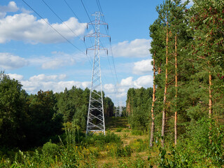 High-voltage power lines on the background of forest and blue sky