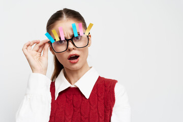 Fashionable young woman with playful glasses and colorful clips, surprised expression against a white background Bright colors enhance the fun and quirky vibe of the image