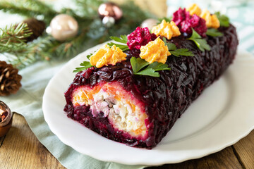 Christmas appetizer New year meal idea. Festive layered salad. Christmas New Year vegetable salad roll with herring and boiled vegetables.