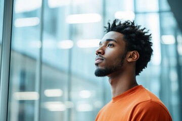 Confident young man gazing upwards in modern city, urban lifestyle concept