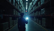 © abu - Uniformed security guard inspecting dark storage aisles with a flashlight, creating dramatic contrasts between light and shadow.