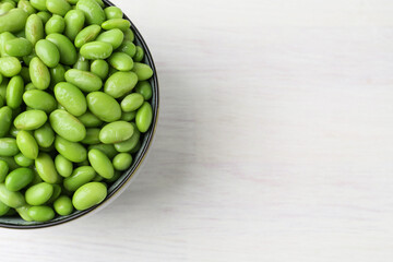 Wall Mural - Fresh edamame soybeans in bowl on white wooden table, top view. Space for text