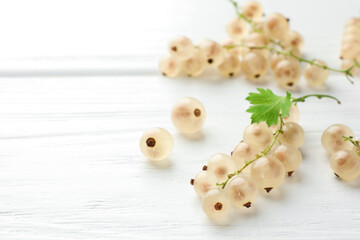 Sticker - Fresh white currant berries and green leaf on white wooden table, closeup. Space for text