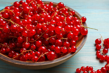 Wall Mural - Fresh red currants in bowl on light blue wooden table, closeup