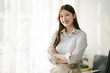 © Daenin - Businesswoman is calculating annual income and expenses at her office. Smiling female employee using laptop in modern office Copy space
