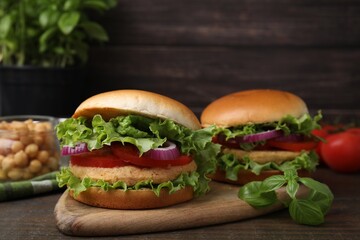 Delicious vegetarian burgers with chickpea cutlets on wooden table