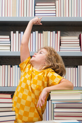 Fototapete - Idea. Elementary schoolboy. Knowledge and education school concept. School boy pupil reading book in library. Kids learn to read. Child reading books in a book store.