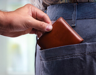 Close-up of a hand stealing a wallet from a person's pocket