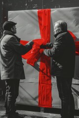 Poster - Two men standing together, holding a large red and white flag