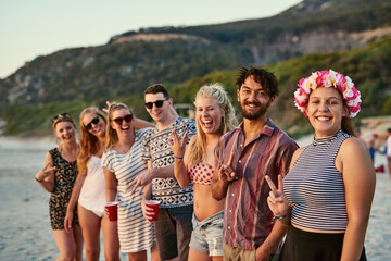 Portrait, group and friends with happy at beach for summer vacation, bonding and travel together in Miami. Smile, people and reunion party with sunshine, peace sign and celebrate on tropical island