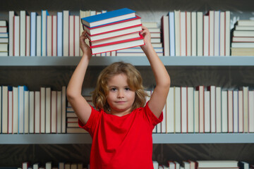 Fototapete - Amazed school kid hold stack of books. Education Concept. Knowledge and education school concept. School boy pupil reading book in library. Kids learn to read. Child reading books in a book store.