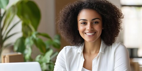 Wall Mural - friendly young latina woman using laptop computer, contemporary home office