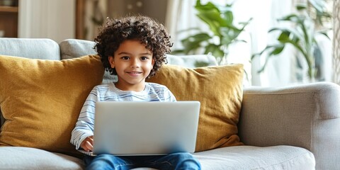 friendly young child using laptop computer, sitting on living room couch