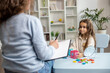 © zinkevych - Cute little girl sitting at the table and having a training session with speech therapist