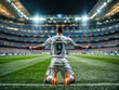 © Gaston - Soccer player in a white uniform kneels on the field at night with arms raised in triumph celebrating a victory.  Football striker with spanish league team number 9 jersey celebrating a goal