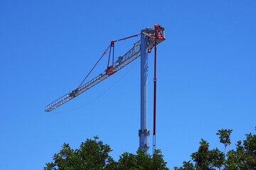 Tall modern construction crane against blue sky