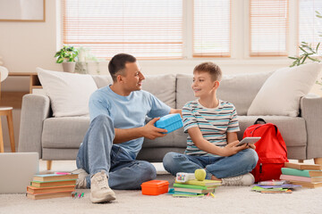 Poster - Father with school lunchbox and his little son packing backpack at home