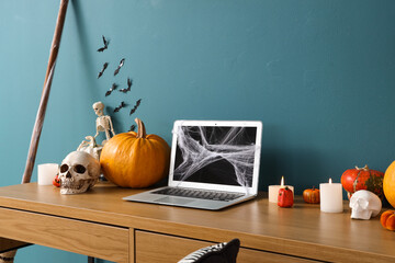 Canvas Print - Workplace with laptop and Halloween decor near blue wall in office