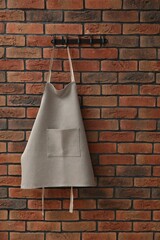 Wall Mural - One chef's apron hanging on brick wall