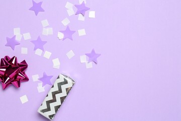 Sticker - Shiny confetti and festive decor on violet background, flat lay. Space for text