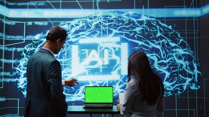 Poster - startup coworkers looking over charts, using ai software on mockup laptop to take data driven decisi