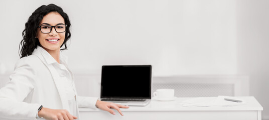 Poster - Online Course, Workshop. Happy mexican woman smiling at camera near computer with blank screen, mock up, copyspace