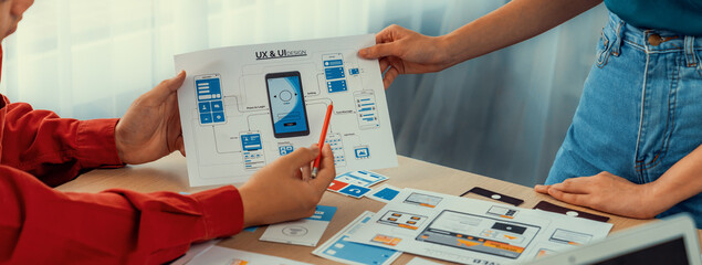 Panorama banner of startup UX developer or company employee design user interface or UI prototype for mobile application or website software with software display on laptop monitor in office. Synergic