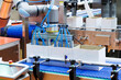 © gumpapa - technology automated robotic arm handling product packaging to cardboard boxes on a conveyor belt in modern industrial production line in factory. innovation logistic and production line system