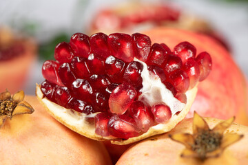 Wall Mural - open pomegranates, and pomegranate seeds on wooden table.