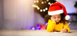 © Prostock-studio - Concentrated little afro girl writing letter to Santa Claus, lying on floor near Christmas tree, free space
